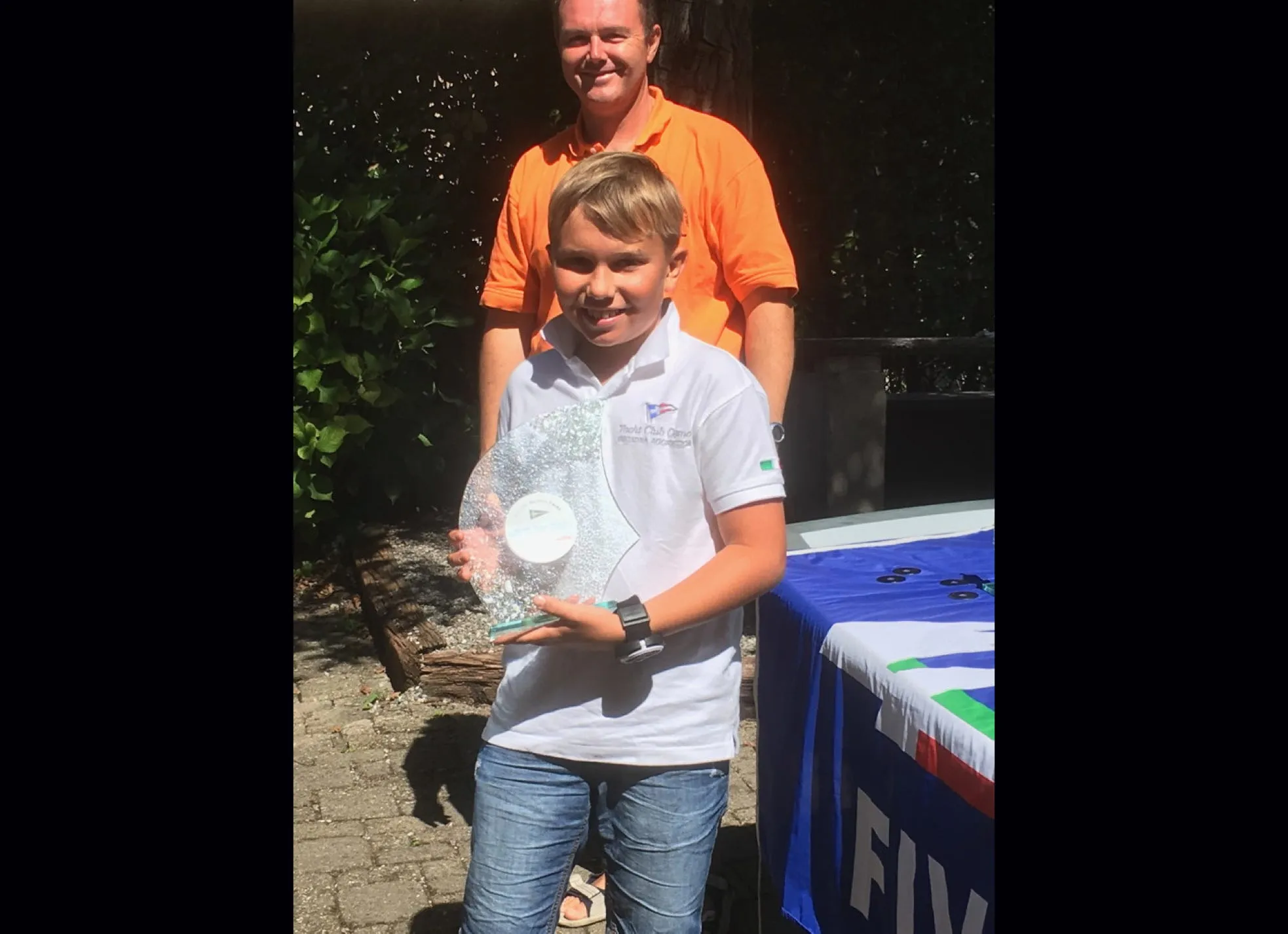 Ragazzo con trofeo di vetro